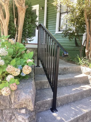 The damaged part has been repaired, and a new black railing has been installed, enhancing both the safety and appearance of the stairs. The steps now look more stable and accessible.