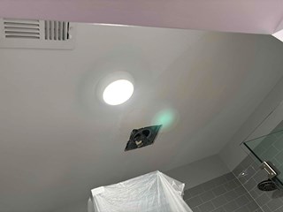The damaged ceiling area has been patched and painted, leaving the surface smooth and restored.