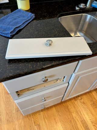 Cabinet drawer is missing its front panel, exposing the interior of the drawer.