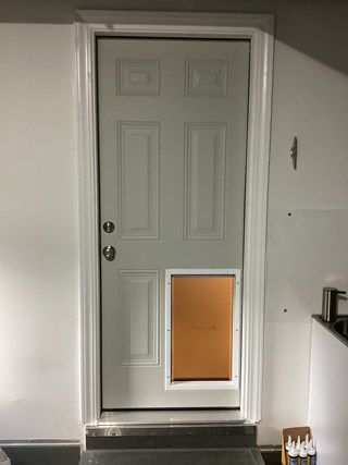 Pet door has been installed into the bottom part of the door. The door still maintains its original design, but now includes a functional opening for pets.