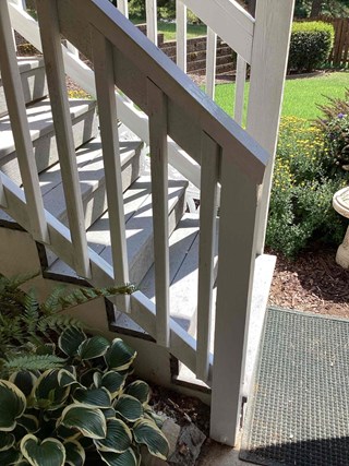 Post after being repaired, with the new section of the post now intact, providing a more solid and visually appealing finish to the stairs.