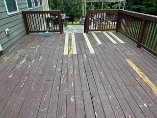 the deck is in poor condition, with visible peeling paint and several planks in need of replacement or repair.
