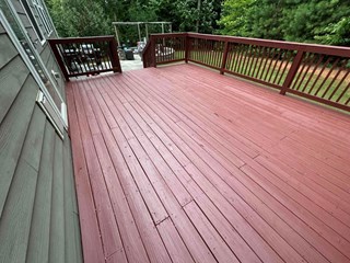 Deck after the repair and repainting. The surface is smooth, freshly painted, and looks well-maintained, with the boards now uniformly treated and restored to a cleaner, more polished appearance.