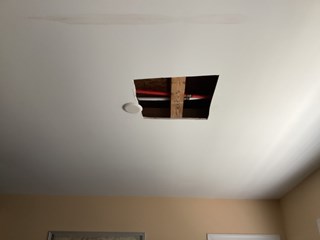 A hole in a ceiling after a water leak. 
