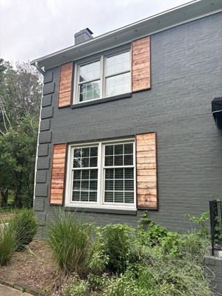 Shutters are unfinished, with raw wood panels that have not yet been stained or painted.