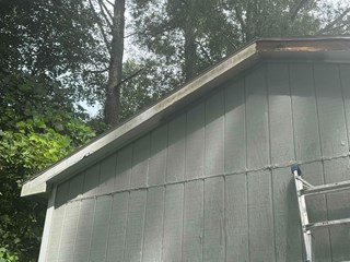 The fascia at the top of the structure has visible damage, including rot and decay, particularly at the corner.