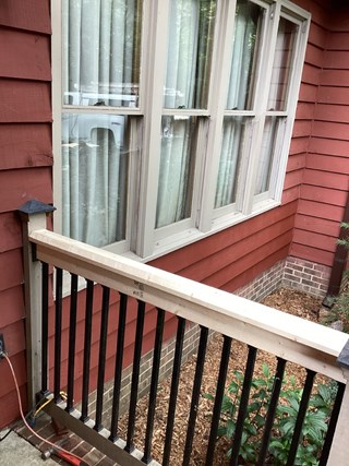 repaired railing, where a new piece of wood has been installed, restoring the railing to a more stable and complete condition.