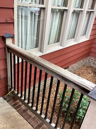 the railing has noticeable damage, with a broken  section of wood at the top of the railing.