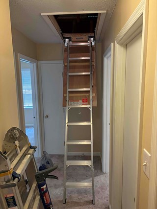 New attic ladder installed, with a modern metal folding ladder providing a much more secure and accessible way to reach the attic.