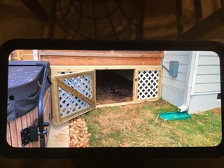 Area after a lattice gate has been installed, closing off the space. The gate is made of wood with a lattice design, creating a more secure and aesthetically pleasing finish that encloses the area beneath the deck.