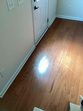 Area after the flooring has been completed. The new planks have been installed, creating a seamless and uniform surface.