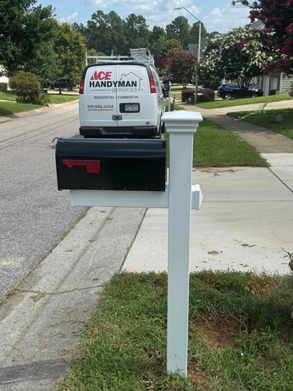 Man in a Gray Long Sleeve Shirt that Says “Ace Handyman Services” on the Back Painting a Door Jamb with a Roller Man in a Gray Long Sleeve Shirt that Says “Ace Handyman Services” on the Back Painting a Door Jamb with a Roller