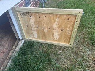 Crawlspace door after it has been replaced with a new, sturdy wooden door.