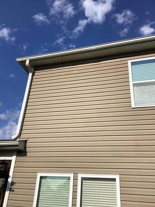 Home exterior after the repairs have been made. The siding has been fixed, with no gaps or visible damage. 