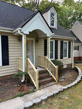entryway after a wooden railing has been installed along the steps, making it safer and more accessible.