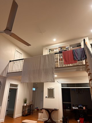 A section of a ceiling with visible damage, including a crack in the drywall on the second floor.  