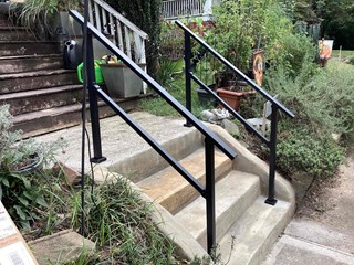 Steps after a railing has been added, enhancing safety and accessibility.