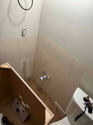 wall after the drywall work has been completed, with the new drywall patched and smoothed out, ready for vanity installation.