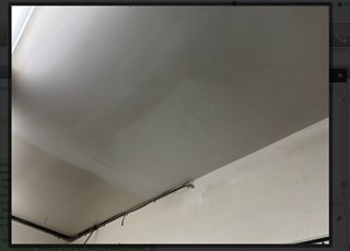 Ceiling after it has been repaired, with the damage addressed and the surface smooth and painted