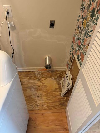 The hole has been patched with new drywall, and the patch has been smoothed and finished with joint compound and dryer vent has been reinstalled.