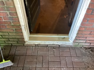 he damaged threshold has been replaced with a new, smooth wooden piece that fits securely against the doorframe. 