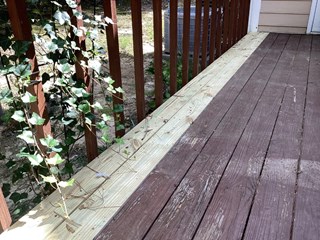 Deck with new boards installed along the edge where the old, damaged boards were.