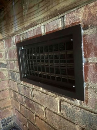 Crawlspace vent, now repaired with a new, clean vent cover.