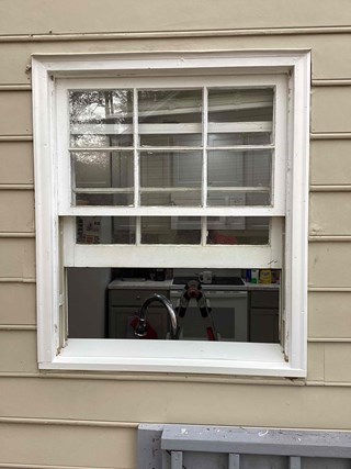 Window after the repair work. The bottom sash is now properly sealed, and the wood frame has been repaired and painted over with fresh white paint. 