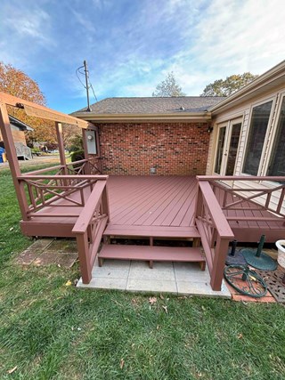 Deck after it has been refinished. The wood is now coated in a rich brown stain, giving the deck a polished, new appearance.