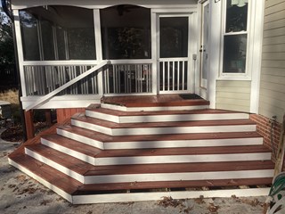 A set of wooden stairs with the wooden steps appearing well-worn, with some visible signs of weathering and discoloration.