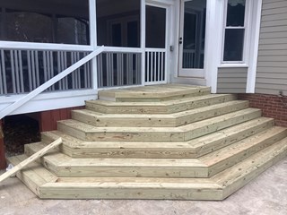 Stairs after a repair. The worn, painted steps have been replaced with new wooden planks, which are still in their natural, unfinished state.