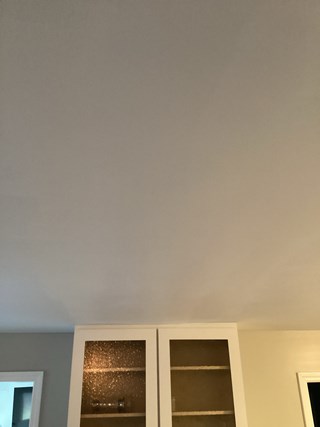 Ceiling after the drywall damage has been repaired. The crack has been fixed, and the area is smooth, with no visible signs of the previous damage.