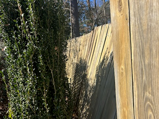 Leaning wooden fence showing signs of damage in Raleigh. 