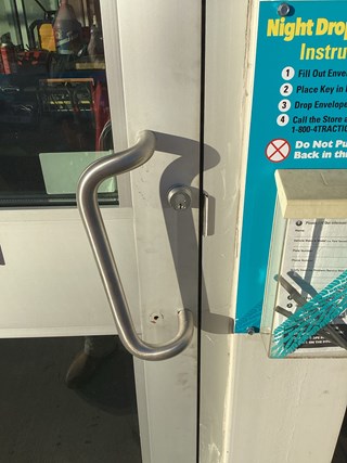 Exterior commercial door with a damaged handle before repair. 