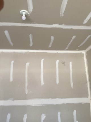 Garage drywall before overhead storage installation by Ace Handyman Services in Wake Forest.