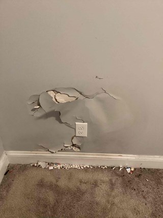Professional drywall repair services needed for this damaged wall in Clayton, NC.