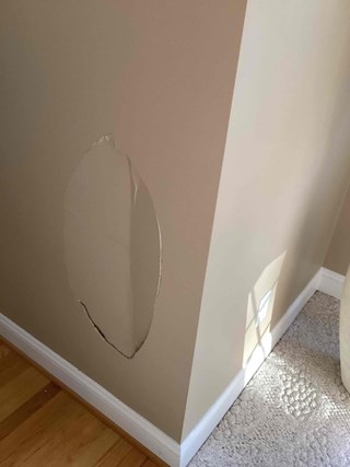 Damaged drywall wall requiring professional repair services.