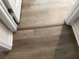 Completed LVP flooring installation in Durham, NC 27703, featuring a transition strip at the doorway for a smooth and professional finish.