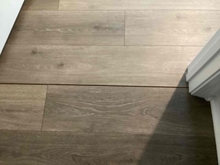 Close-up of newly installed luxury vinyl plank (LVP) flooring in Durham, NC, before the addition of a transition strip.