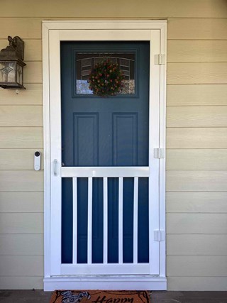  After photo of a professionally installed storm door in Apex, NC. The white storm door complements the blue front door and adds an extra layer of insulation and protection.