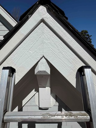 After photo of successful carpentry woodpecker damage repair. Gable end restored with woodputty, seamlessly integrated, and painted white in Raleigh, NC.