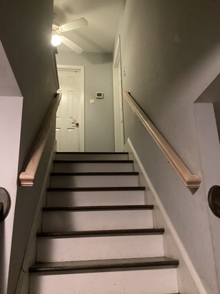 After photo of stairs with handrail installation in Raleigh, North Carolina, showing stairs with a newly installed light-colored wooden handrail.