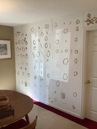 Before photo of drywall repair in Raleigh, North Carolina 27614, showing circular markings and tape indicating damage. Highlighting drywall patching and repair services.
