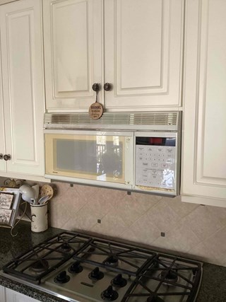 Before photo of microwave replacement in Cary, North Carolina, showing an old GE Spacemaker XL over-the-range microwave. Highlighting kitchen appliance replacement services.