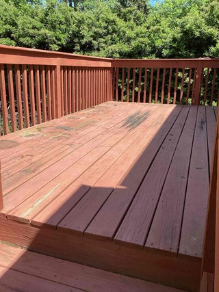 Wooden deck with red stain showing signs of aging and deterioration