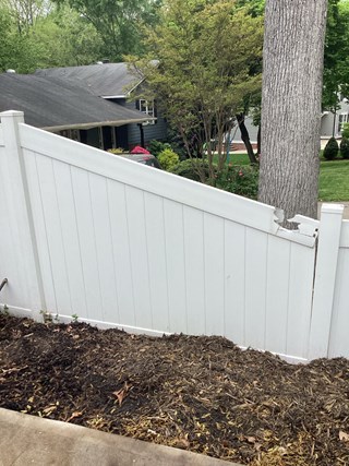 Vinyl fence showing damage at the top from something falling on it