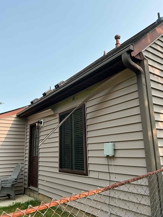 Vinyl siding visibly damaged by wind storm damage in Raleigh NC 27613 before handyman repairs 
