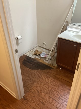 Water damaged wood flooring due to a toilet leak before handyman repairs in Durham NC 27703