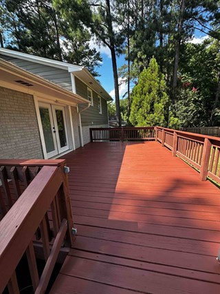 Freshly stained redwood deck restoration in Apex, NC 27502 by Ace Handyman Services craftsmen Noe and Cody, enhancing outdoor living space and curb appeal.