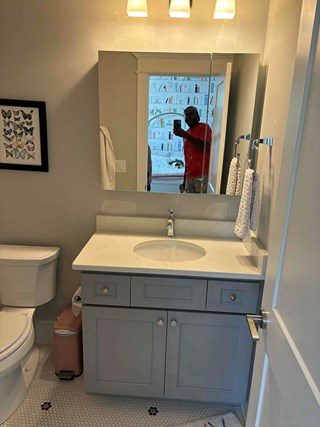 Bathroom, with the mirror installed above the sink. 